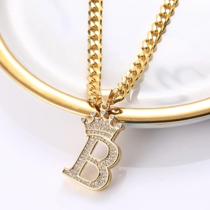 Détail du pendentif couronne lettre B doré avec oxydes de zirconium sur chaîne cubaine