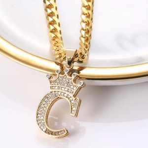 Vue macro du pendentif couronne lettre C plaqué or avec zircon et chaîne cubaine