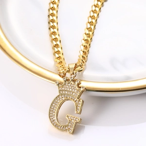 Détail du pendentif couronne lettre G doré avec zircons brillants sur une chaîne cubaine