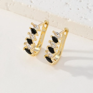 Détail de boucles d'oreilles dorées 18K avec pierres marquises noires et blanches