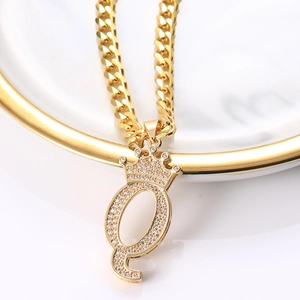 Détail du pendentif lettre Q couronne dorée avec zircons sur une chaîne maille cubaine