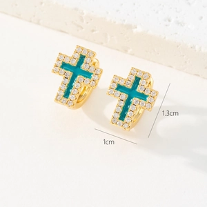 Détail macro de boucles d'oreilles croix plaquées or 18K avec émail bleu et CZ