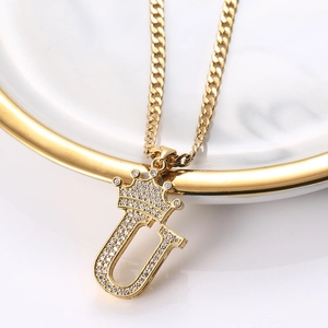 Vue macro du pendentif lettre U couronne dorée avec zircone sur une chaîne cubaine