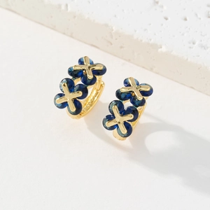Détail de boucles d'oreilles trèfle vintage dorées 18K avec zircons bleus fins