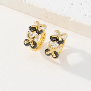Détail des boucles d'oreilles trèfle plaquées or 18K avec zircons noirs et transparents