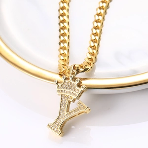 Détail de chaîne cubaine dorée avec pendentif lettre Y à couronne et zircons brillants