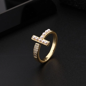 Detailed view of gold T-shape ring with pearl and micro-paved cubic zirconia accents