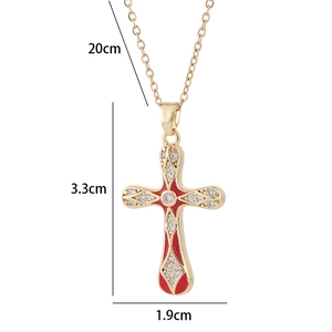 Collana con ciondolo a croce dorata vintage con smalto rosso e zirconi su sfondo bianco