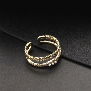 Detailed close-up of double layer gold ring with white pearls and sparkling zircon stones