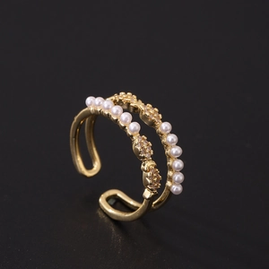 Detail of double-layer gold plated ring featuring white pearls and cubic zirconia stones