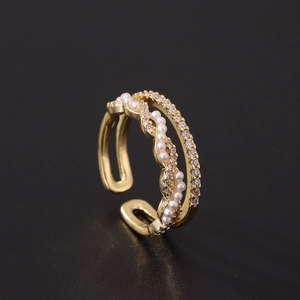 Elegant gold layered ring with pearls and pavé cubic zirconia on black background