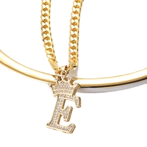 Collier hip hop avec pendentif lettre E couronne dorée et chaîne cubaine sur fond blanc