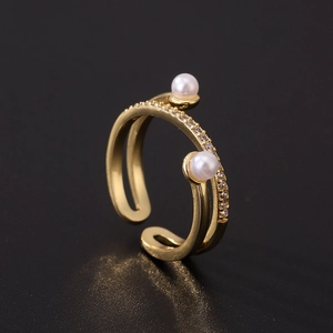 Detail view of gold-plated open ring featuring two pearls and shimmering cubic zirconia pavé