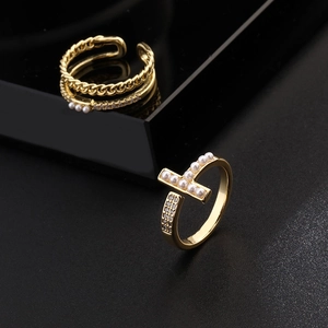 Macro shot of gold-plated pearl rings with cubic zirconia and woven chain detail