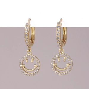 Dettaglio orecchini huggie placcati in oro con ciondoli a forma di smiley e zirconi luccicanti