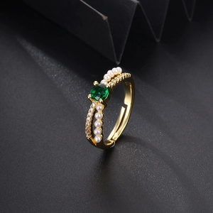 Detail of adjustable gold ring with green gemstone, small pearls and pavé set zircons