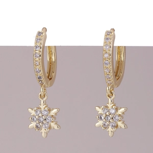 Dettaglio di orecchini placcati oro con ciondoli a fiocco di neve in zirconia scintillante