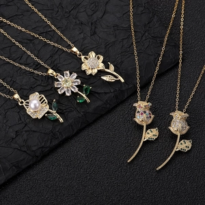 Gold flower necklace collection with crystal petals and pearls on a black background