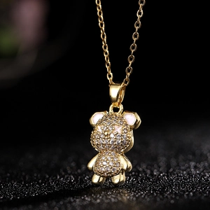 Vista macro de collar con colgante de oso dorado con circonitas blancas y esmalte rosa