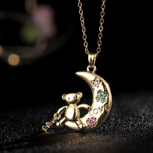 Macro de colgante de luna y oso dorado con piedras de circón moradas y verdes