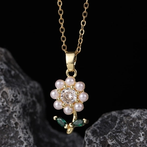 Elegant gold flower necklace with pink pearl petals and green gemstone leaves detail