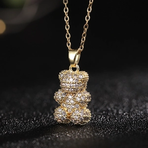 Vista macro de un collar con colgante de oso dorado con piedras de circón brillante