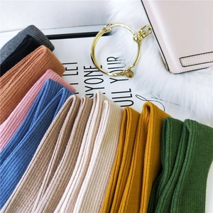 Colorful knitted arm warmers in various colors like grey, pink, and blue with rib texture
