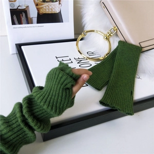 Dark green knitted arm warmers with thumb holes and vertical ribbed texture for winter fashion
