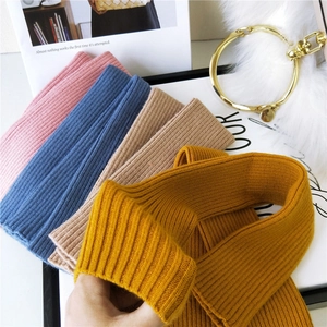 Knitted ribbed arm warmers in various pastel colors displayed with stylish accessories