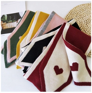 Detail of colorful knitted scarves with heart patterns showcasing various color combinations