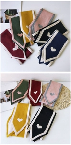 Detail view of colorful knit scarves with heart patterns in various seasonal colors