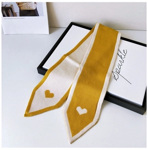 Detailed knit texture of ginger and white scarf featuring heart-shaped jacquard patterns
