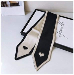 Detailed knit texture of a black and white scarf featuring heart jacquard patterns