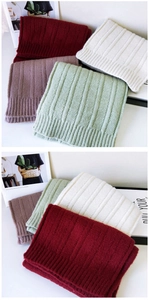 Detailed knit texture of thick winter scarves in burgundy, cream, and pastel colors