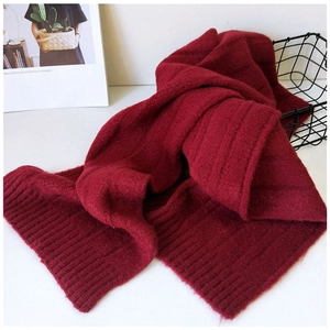 Detailed view of thick dark red knitted scarf with vertical stripe texture for winter