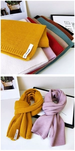 Detail von dicken Strickschals in verschiedenen Farben mit modischen Textiletiketten