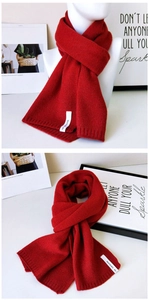 Detail eines roten Strickschals mit modischem Markenetikett und geripptem Saum