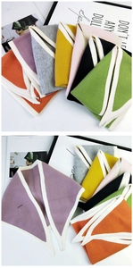 Close-up of knit triangle scarves in vibrant colors with contrast white edge detailing