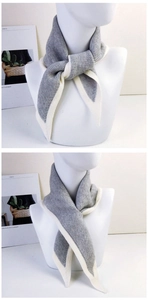 Detail of grey knitted scarf with white contrast edges and dual styling methods