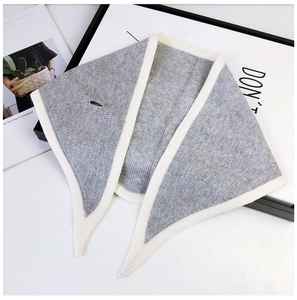 Detail of grey knitted triangle scarf with cream contrast edge and functional buttonhole
