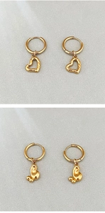 Détail de boucles d'oreilles cœur dorées avec texture martelée et finitions polies