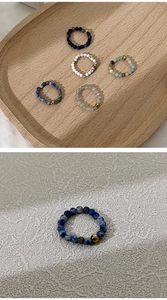 Detail macro-opname van 4mm natuurstenen kralenringen met gouden accenten