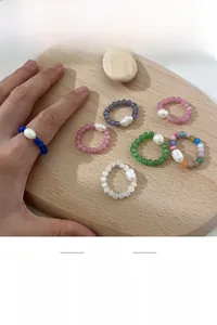 Detailed macro view of handcrafted cat eye bead rings with baroque pearls and elastic band