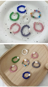Detail of baroque pearl rings with colorful cat eye stones on a ceramic plate