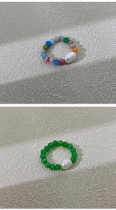 Detail of beaded rings with colorful cat eye stones and irregular baroque pearls