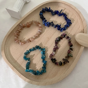 Set di quattro bracciali con scaglie di pietre naturali su un vassoio di legno