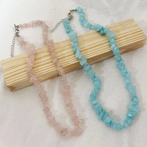 Bohemian irregular natural stone necklaces in pink and blue on a wooden stand
