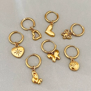 Ensemble de sept boucles d'oreilles dorées avec pendentifs papillon et cœur ajourés