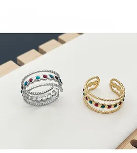 Macro shot of layered hollow dotted rings with colorful enamel in gold and silver finish