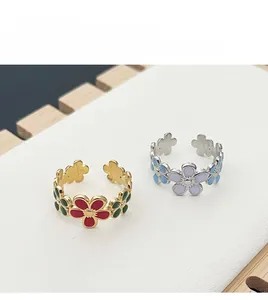 Detail of adjustable flower rings featuring colorful enamel petals in gold and silver finish
